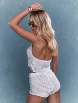 Conjunto de top corto tejido a crochet con cuello halter y lentejuelas, y short a juego.