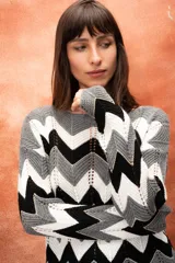 Sweater tejido calado con diseño de chevrón en blanco, negro y gris, con detalles de lurex dorado.