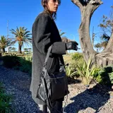 Bolso tipo tote de cuero sintético color marrón, con doble asa de hombro y cierre superior. Incluye monedero de regalo.