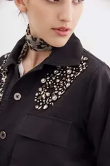 Campera verde militar de gabardina de algodón con corte holgado y cordón de ajuste en la cintura. Decorada con bordados de piedras en los hombros.