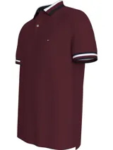 Chomba Tommy Hilfiger color borgoña de corte regular, confeccionada en algodón orgánico y elastano. Presenta cuello tipo polo con cartera de dos botones, detalles distintivos de la marca y logo bordado en el pecho.