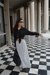 Pollera larga de viscosa con estampado de lunares blancos sobre fondo negro.