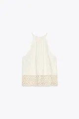 Top blanco de cuello halter con detalle de crochet en el ruedo.