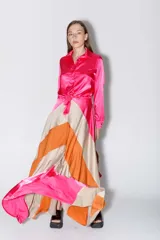 Falda larga de satén con diseño de bloques de color en forma de V en tonos fucsia, naranja y beige.