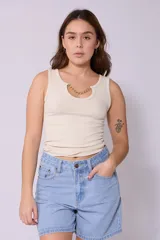 Musculosa color crema de corte ajustado, con cuello redondo y detalle de cadena dorada en el escote.