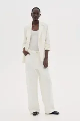 Blazer entallada color blanco, confeccionada en mezcla de viscosa. Modelo con hombreras, solapas de muesca, mangas tres cuartos fruncidas y bolsillos delanteros con solapa. Sin cierre y forrado.