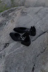 Sandalias bajas de cuero con estampado animal print de vaca en blanco y negro, con pulsera al tobillo y taco cuadrado.