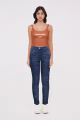 Musculosa blanca de algodón con elastano, breteles finos, corte cropped, cuello redondo y bordado frontal con texto y flores.