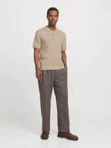 Polo de punto color beige con cuello clásico, mangas cortas y cierre con botones.