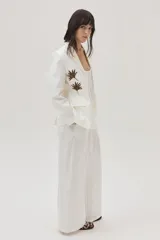 Blazer de lino color blanco con bordados en tonos marrón dorado y plateado, al frente y en la espalda.