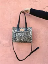 Cartera bandolera Shill Mini de cuero con estampado animal print, forro de tela y correa larga negra regulable. Cuenta con bolsillo frontal con cierre y bolsillo interno. Fabricación nacional.