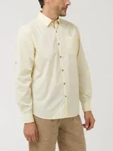 Camisa de manga larga color verde claro, confeccionada en popelina de algodón orgánico. Cuenta con cuello camisero, botones de madera, bolsillo en el pecho con logo bordado y protección UPF +20.