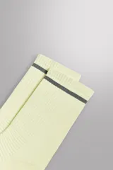 Calcetines deportivos color verde oliva, tejidos con estructura compacta y elástica, con detalle de una línea horizontal azul en el borde superior. Zara Athleticz engineered.