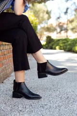 Botín negro de cuero con elástico lateral de gamuza y taco cuadrado bajo.