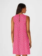 Vestido corto color rosa con estampado de pequeñas formas blancas, de corte suelto y sin mangas.