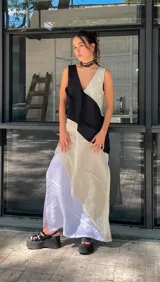 Vestido largo de lino con escote en V, diseño color block en blanco, negro y celeste, y costuras a la vista. Tiene tajos laterales.