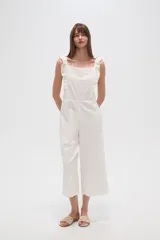 Mono de algodón blanco con bordado broderie, cuello cuadrado y volados en los breteles. Presenta un diseño entallado en el torso y pantalones de pierna ancha.