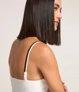 Blusa de breteles finos color blanco con escote en V y superposición contrastante en negro, confeccionada en crepé.