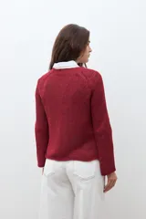 Sweater de tejido de punto color verde oliva jaspeado, con escote redondo y mangas largas con ligero acampanado en los puños.