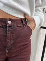 Pantalón de denim elastizado color borgoña, de corte ajustado.