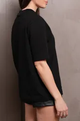 Remera negra de manga corta, cuello alto y logo plateado en el pecho.