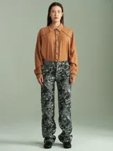 Pantalón largo de algodón grueso con estampado floral en tonos grises y negros. Diseño tipo jean con bolsillos delanteros y traseros, calce cómodo y tiro medio-alto.