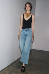 Pantalón de jean azul oscuro, de tiro alto, corte wide leg y largo al tobillo.