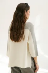 Buzo de punto color beige con mangas 3/4 y detalle bitono en cuello y mangas.