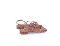 Sandalia de cuero color suela, con tiras finas y detalle frontal trenzado en colores celeste, naranja y amarillo. Pulsera ajustable con hebilla metálica y base plana con taco bajo geométrico.