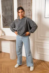 Sweater blanco de algodón con cuello redondo y mangas largas. Decorado con tachas plateadas en el frente y las mangas.