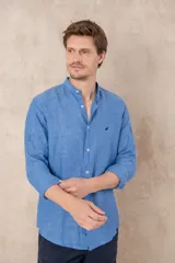 Camisa celeste de lino con cuello mao, corte slim fit, manga larga con puños abotonados y cierre frontal con botones.
