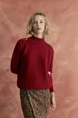 Sweater rojo de tejido de punto con cuello alto y diseño de rombos en el frente.