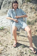 Short de sarga con estampado floral en tonos azules, bajo levemente redondeado, corte holgado, tiro alto y elástico revestido en la cintura.