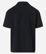 Camisa negra de sarga, corte boxy, con cuello inglés, manga corta, abotonadura frontal y bolsillo en el pecho.