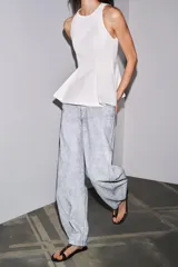 Pantalón de jean de tiro medio con pierna ancha y corte tapered, confeccionado en tejido de algodón revestido color gris claro. Cuenta con bolsillos delanteros y traseros, trabillas en la cintura y cierre frontal con cremallera y botón.