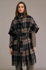 Tapado tipo capa con mangas tres cuartos, confeccionado en mezcla de lana a cuadros en tonos negro, azul, caqui y chocolate. Presenta cuello pequeño con cierre de botón, cierre cruzado con cinturón de tela a juego, mangas anchas hasta el codo, corte holgado y dobladillo con flecos.
