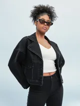 Campera de jean negra con corte cropped, cuello clásico, cierre frontal con botones metálicos y bolsillos con solapa en el pecho.