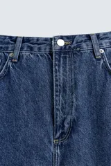 Pantalón de jean azul oscuro, corte tapered wide fit, tiro medio, cinco bolsillos, detalle de texto bordado en trasero, efecto lavado y cierre frontal con cremallera y botón.