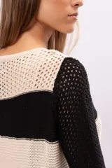 Minivestido tejido a crochet con rayas horizontales en color crudo y negro, con mangas acampanadas y terminaciones en color bordó.