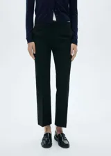 Pantalón negro de vestir, de tiro medio, corte recto y largo al tobillo.
