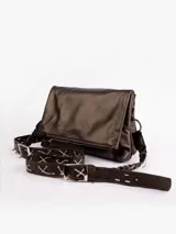 Bandolera de cuero color marrón oscuro con solapa y correa de cuero ajustable con tachas y cadena plateada.