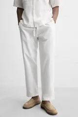 Pantalón azul marino de corte amplio, confeccionado en tejido de mezcla de algodón y lino. Cuenta con cintura elástica ajustable con cordón, bolsillos frontales y bolsillos traseros de vivo.