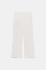 Pantalón negro de tiro medio con bolsillos delanteros y traseros. Cintura elástica ajustable con cordones.