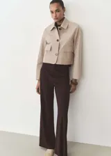 Pantalón largo de mujer color beige, de corte ancho y tiro alto, con cintura elástica y lazo ajustable.