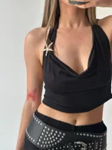 Top halter negro con escote drapeado y detalle de estrella dorada en el cuello.