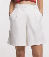 Bermuda de lino color blanco, con cintura alta, trabillas y pliegues.