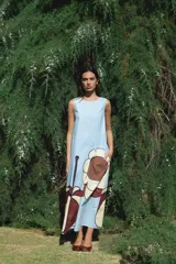 Vestido largo celeste sin mangas con estampado de flores marrones y bolsillo lateral.