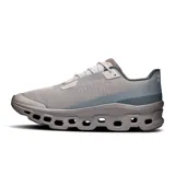 Championes de running On Cloudmonster Void, color gris con detalles en celeste y blanco. Presentan suela con tecnología CloudTec y diseño con perforaciones hexagonales.