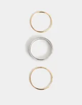Set de tres pulseras rígidas de metal, una plateada y dos doradas, de diferentes tamaños.