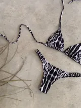 Conjunto de bikini verde esmeralda, con corpiño triangular de atar al cuello y espalda, con almohadillas desmontables, y bombacha colaless con laterales fijos.